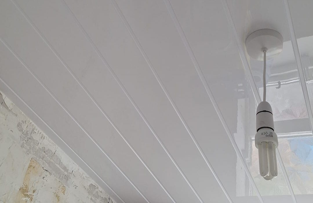 Ceiling panelled in white PVC tongue and groove effect